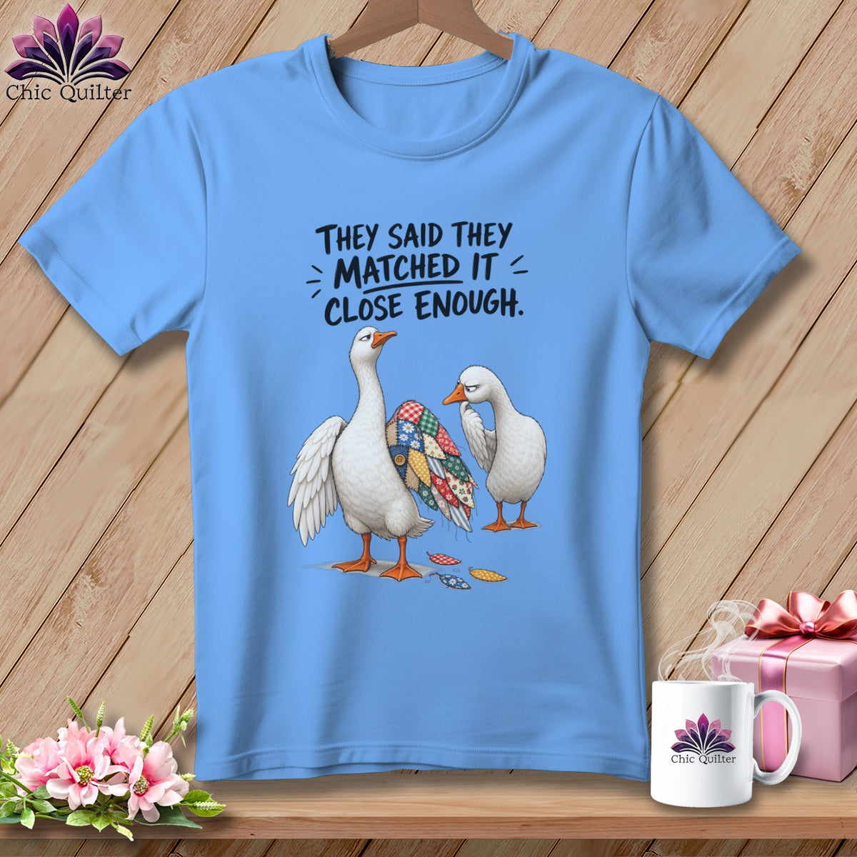 Blue t-shirt with geese wearing patchwork and text "They said they matched it, close enough."