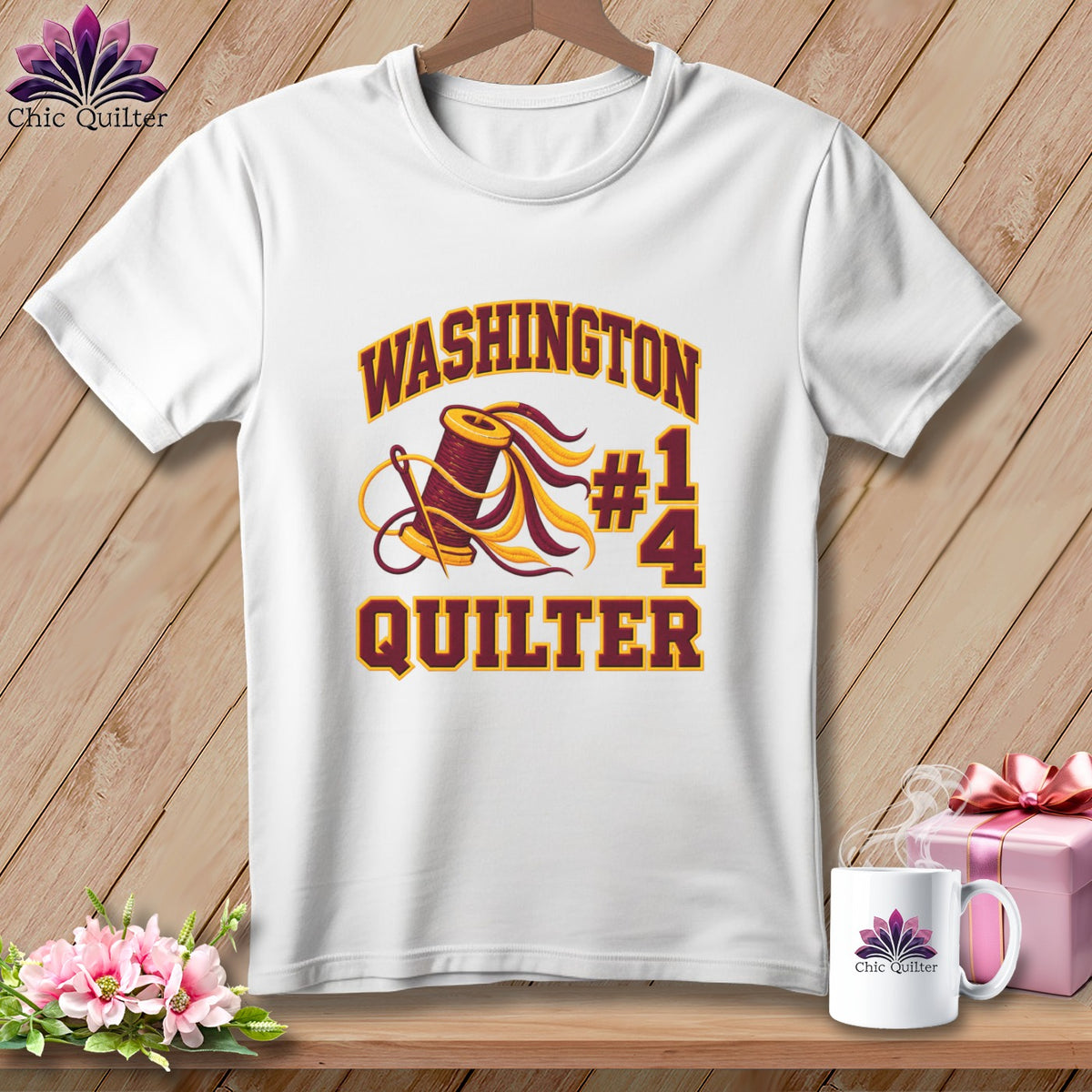 White t-shirt with a maroon and gold graphic featuring a spool of thread and the text Washington Quilter.