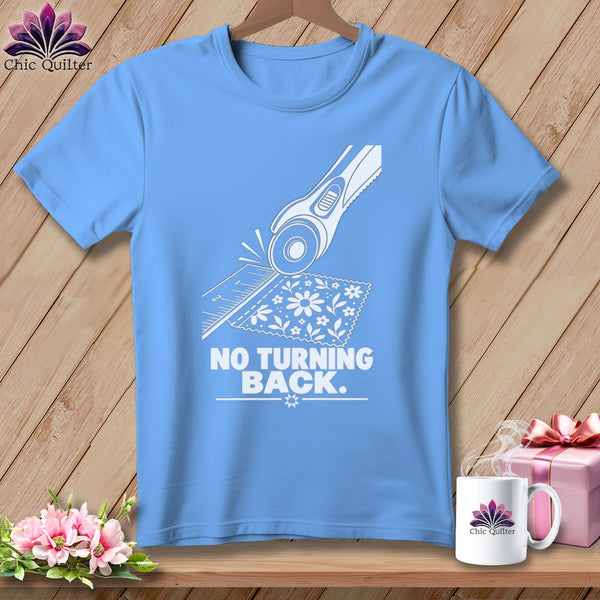 Blue t-shirt with graphic of rotary cutter, ruler, and fabric, text "NO TURNING BACK."