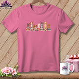 Pink t-shirt with a graphic of seven puppies sitting on colorful quilts.