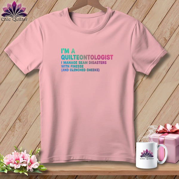 Pink t-shirt with text "I'M A QUILTEONTOLOGIST I MANAGE SEAM DISASTERS WITH FINESSE (AND CLENCHED CHEEKS)".