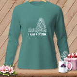 Teal long-sleeve shirt with white graphic of stacked fabric and pile of scraps, reading 