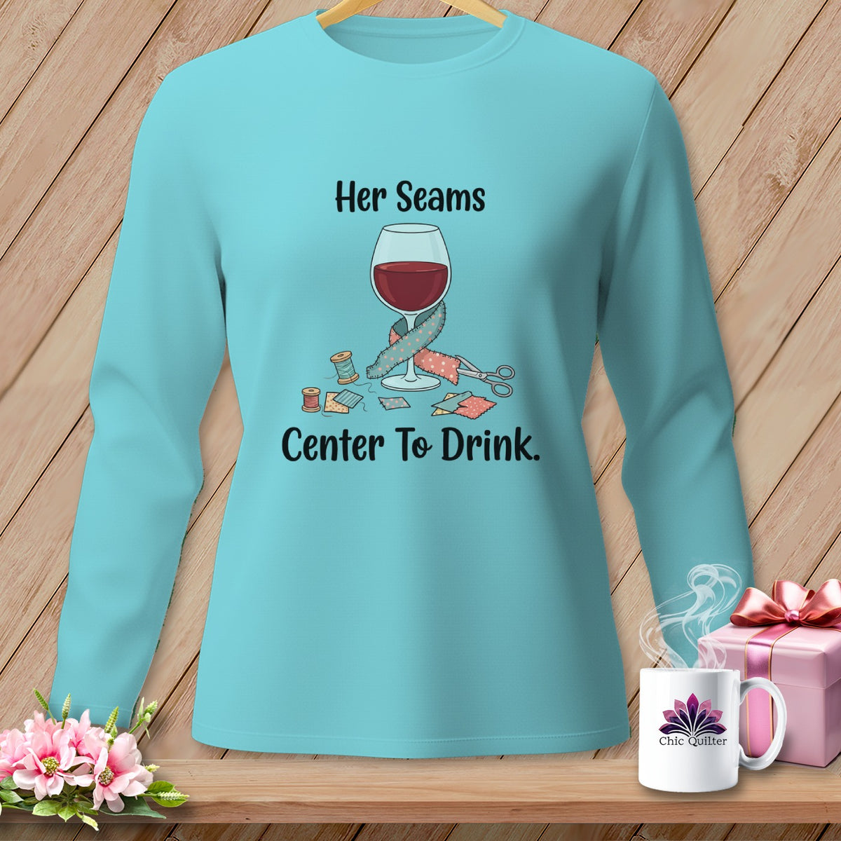 Aqua long-sleeve shirt with "Her Seams Center To Drink" text and sewing graphics.