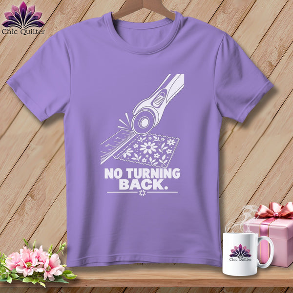 Purple t-shirt with white graphic of rotary cutter, ruler, fabric and text "NO TURNING BACK".