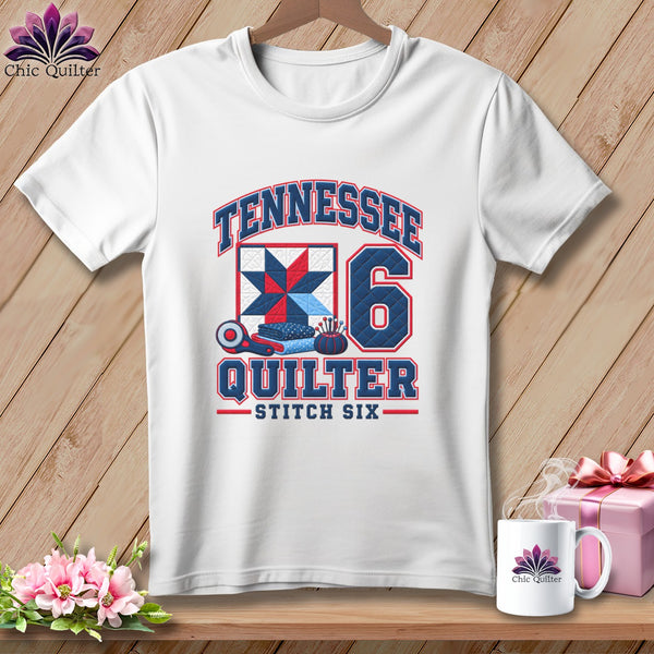 A white t-shirt features a graphic with the text TENNESSEE QUILTER STITCH SIX, a quilt block, a rotary cutter, and the number six.