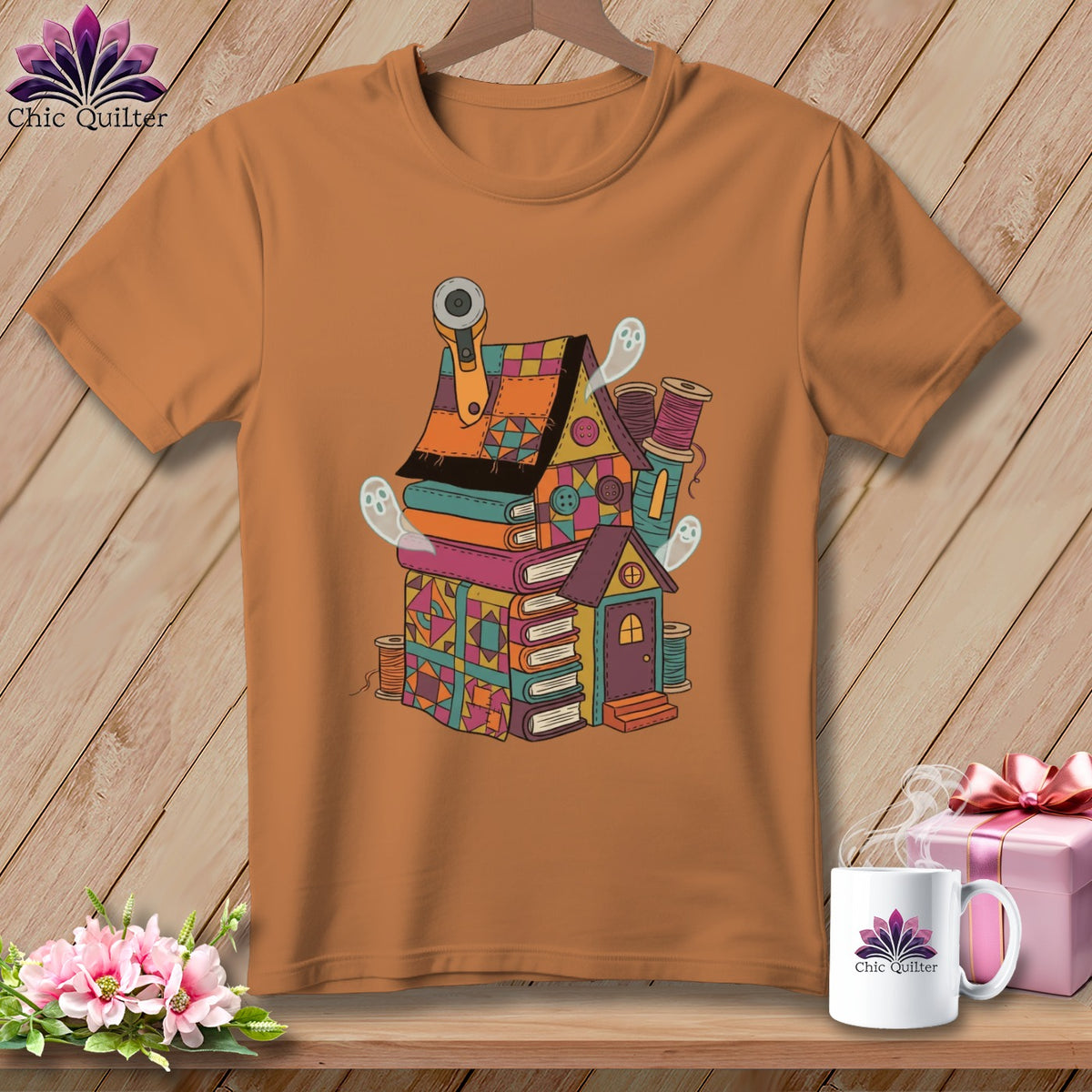 T-shirt with a quirky sewing-themed house illustration featuring books, ghosts, and sewing supplies.