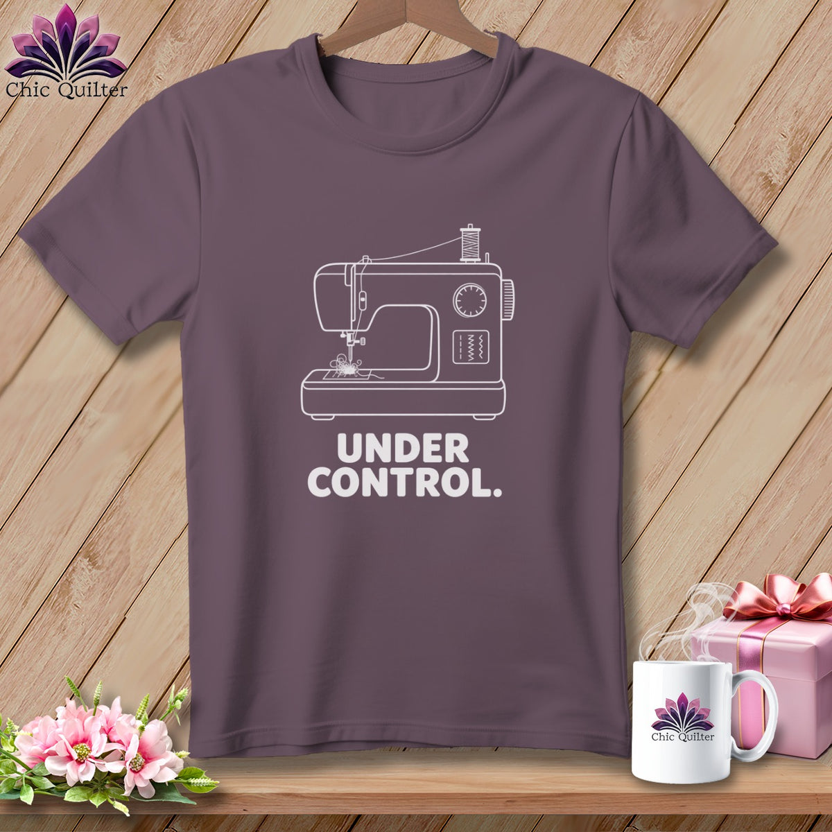 Purple t-shirt with white line art sewing machine and text "UNDER CONTROL."