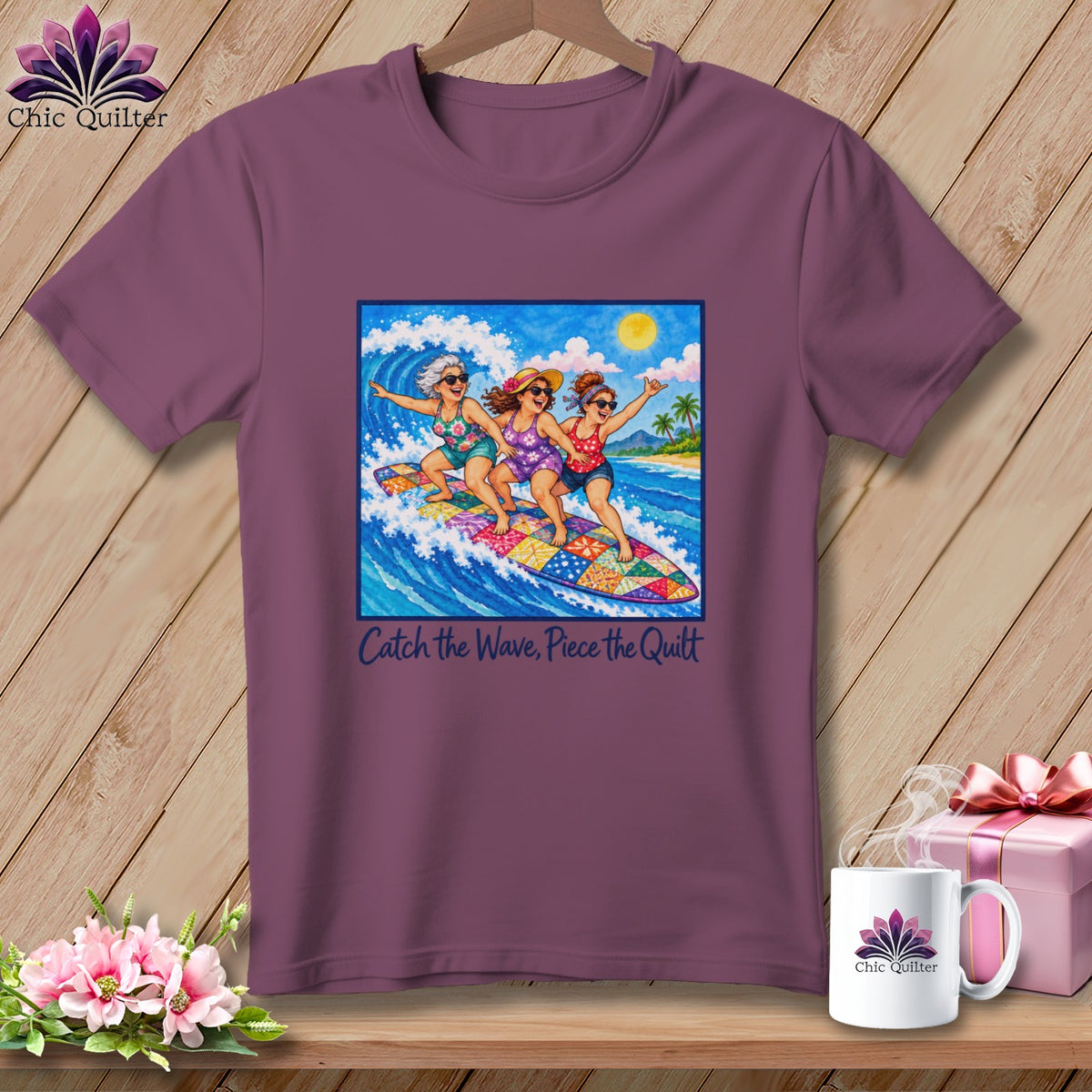 Plum t-shirt featuring three women surfing on a colorful patchwork surfboard with the text Catch the Wave, Piece the Quilt.