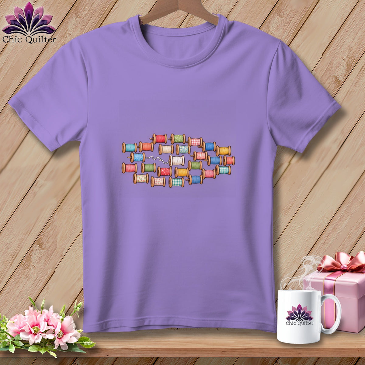 Purple crewneck t-shirt featuring a central graphic of colorful spools of thread.