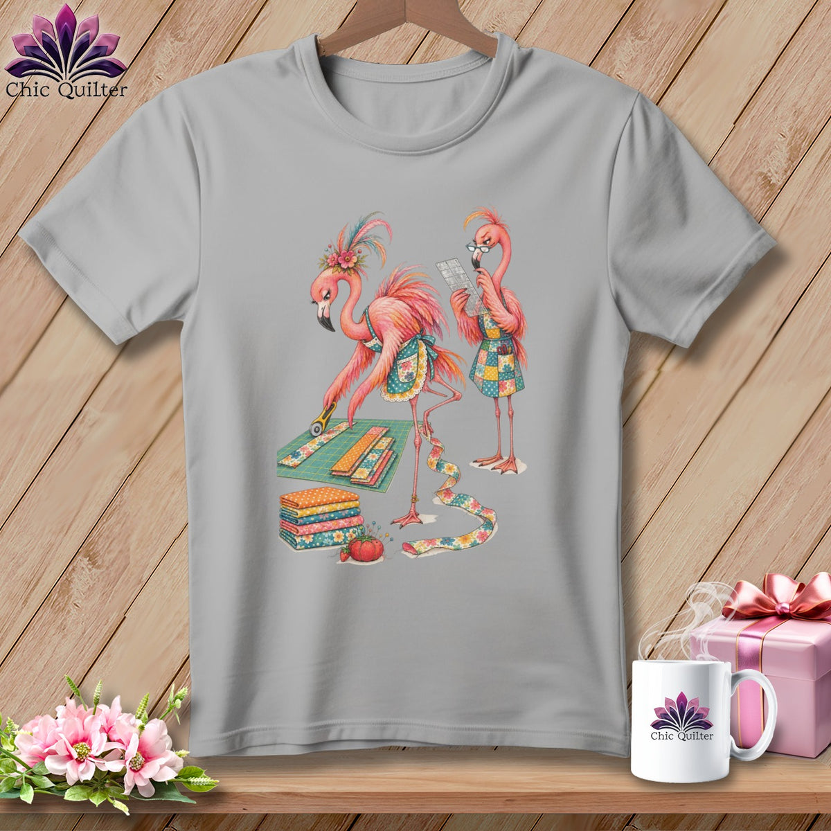 Two flamingos are shown quilting on a grey t-shirt.