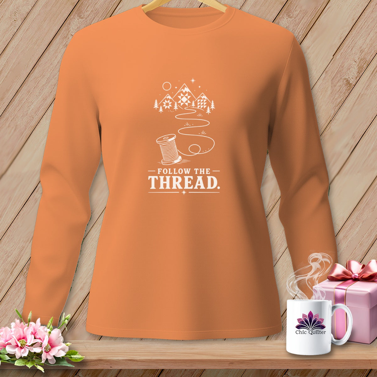 Orange long sleeve shirt with "Follow the Thread" and spool graphic.