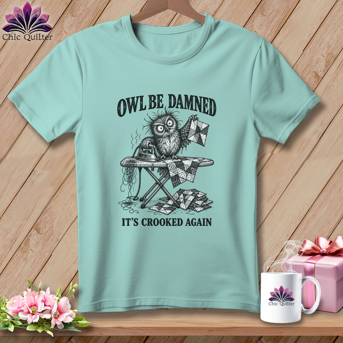 T-shirt with a cartoon owl ironing crooked quilt pieces, text "OWL BE DAMNED IT'S CROOKED AGAIN".