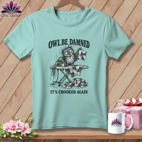 T-shirt with a cartoon owl ironing crooked quilt pieces, text "OWL BE DAMNED IT'S CROOKED AGAIN".