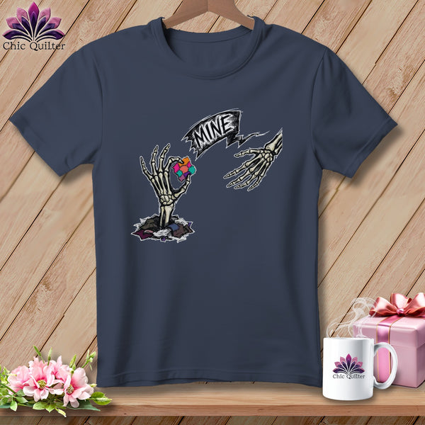 Dark navy t-shirt with skeleton hands holding puzzle piece cube and banner reading "MINE".