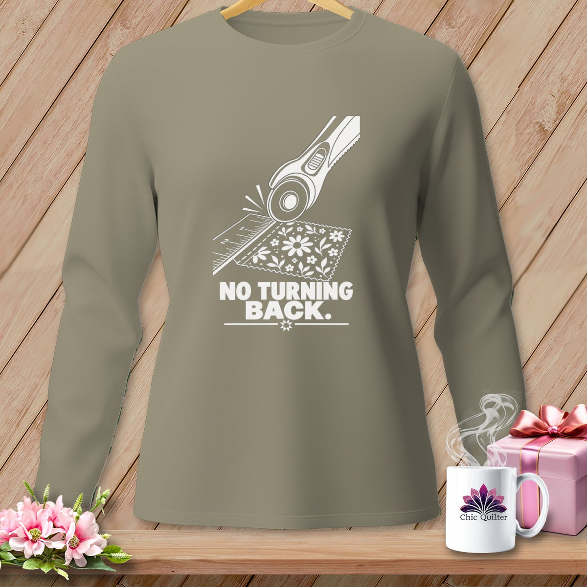 Long sleeve shirt with graphic of rotary cutter over floral fabric and text "NO TURNING BACK".