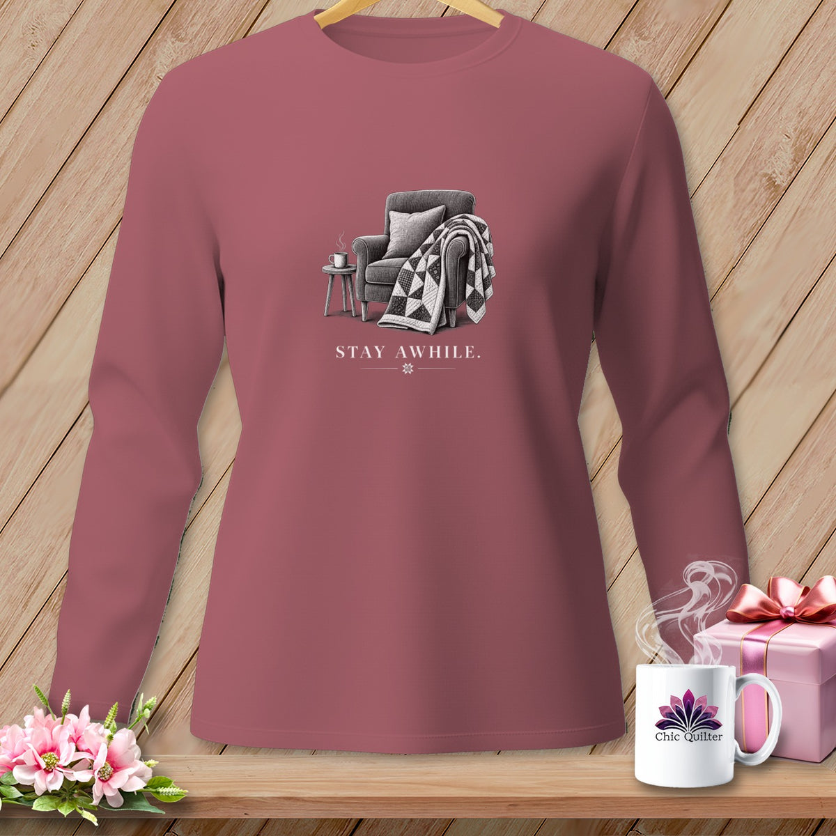 Rose long-sleeve shirt with "STAY AWHILE" and chair graphic.