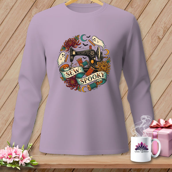 Lavender long-sleeve shirt with "Sew Spooky" text on a banner, sewing machine, ghosts, and flowers.