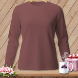 Long-sleeve maroon t-shirt on wooden background with pink gift and flowers.