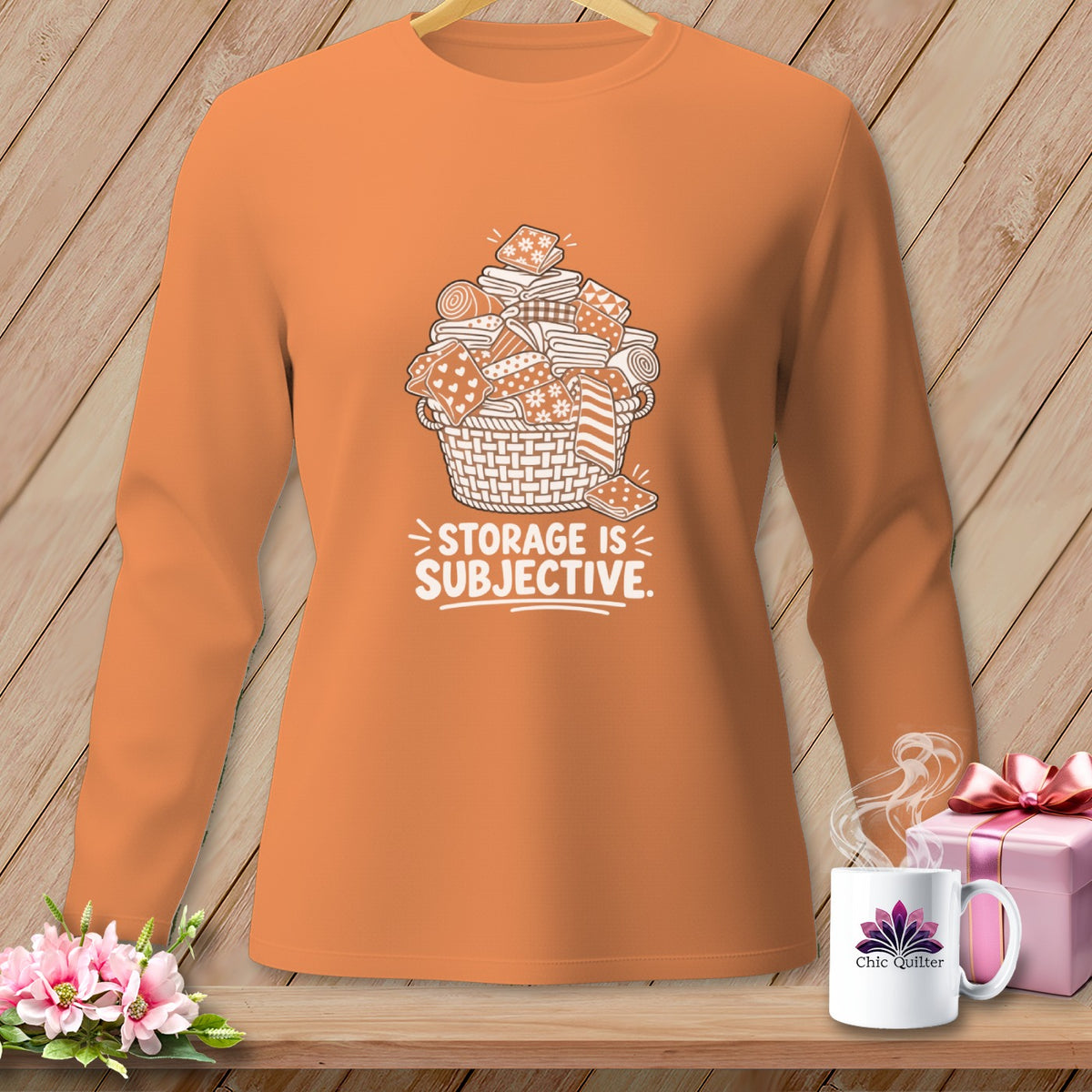 Orange long-sleeve shirt with white graphic of fabric scraps in a basket and text.
