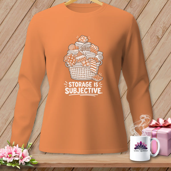 Orange long-sleeve shirt with white graphic of fabric scraps in a basket and text.