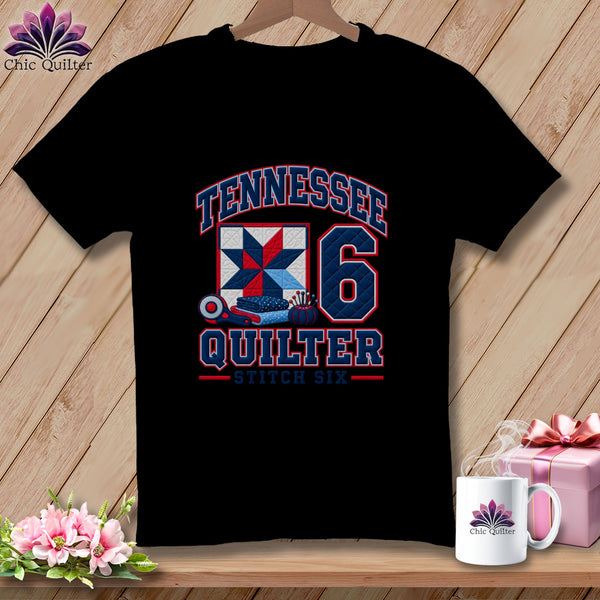 A black t-shirt features a red, white, and blue Tennessee Quilter graphic with a quilt block and rotary cutter.
