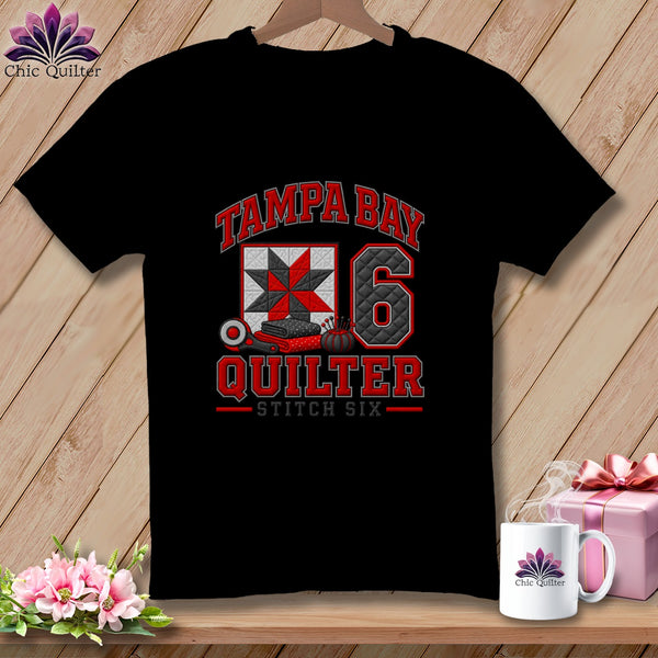 A black crewneck t-shirt featuring a red, white, and black Tampa Bay Quilter Stitch Six graphic.