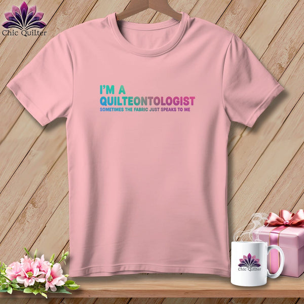 Pink t-shirt with "I'M A QUILTEONTOLOGIST SOMETIMES THE FABRIC JUST SPEAKS TO ME" text.