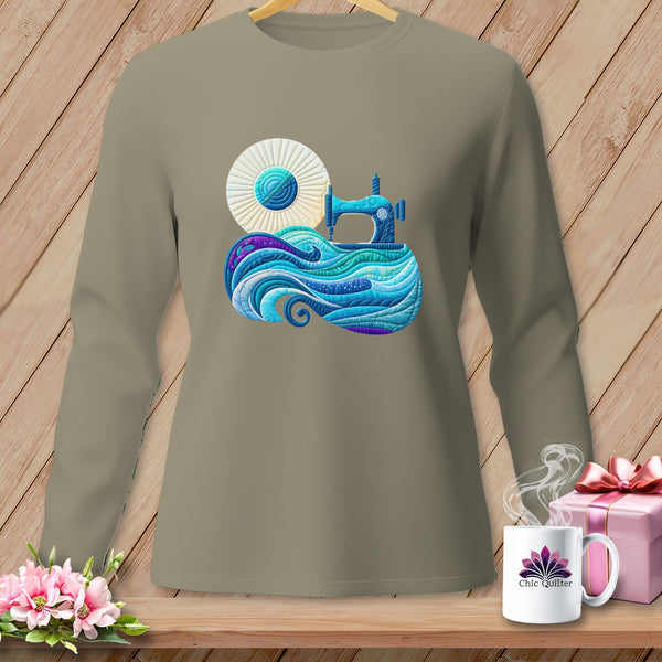 Long sleeve taupe shirt with a blue sewing machine over a quilt-like wave design.