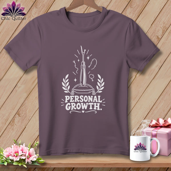 T-shirt with white graphic of thimble, needle, and thread, text "PERSONAL GROWTH".