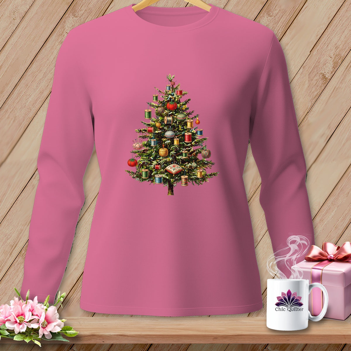 Pink long-sleeve shirt with a Christmas tree decorated with sewing notions.