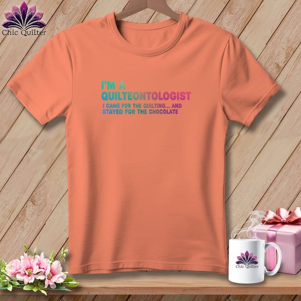 Peach t-shirt with "I'm a Quilteontologist" and quilting/chocolate text.