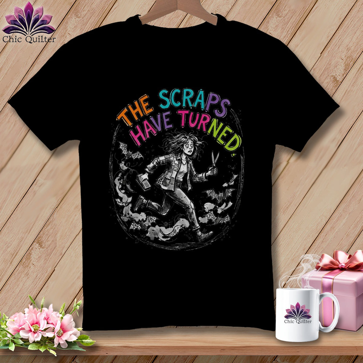 Black t-shirt with illustration of woman running with scissors and bats, text "THE SCRAPS HAVE TURNED".