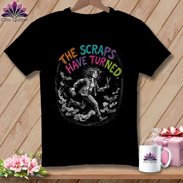 Black t-shirt with illustration of woman running with scissors and bats, text "THE SCRAPS HAVE TURNED".