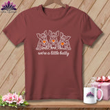 Maroon t-shirt with white line art of three bats holding wine glasses and text 