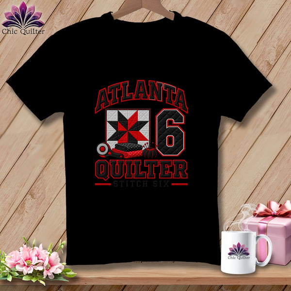 Black t-shirt featuring a red and white quilt block graphic, sewing supplies, and text reading Atlanta Quilter Stitch Six.