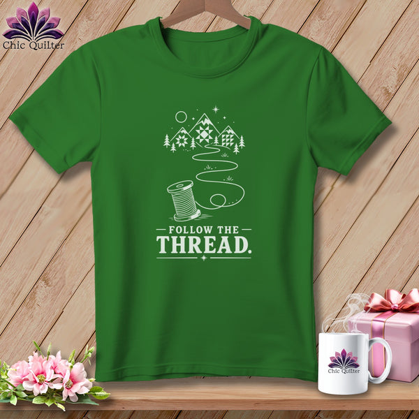 Green t-shirt with a spool of thread design and "Follow the Thread" text.
