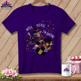 Purple t-shirt with witch at sewing machine and text 