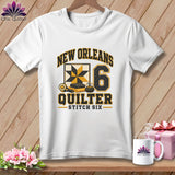 White t-shirt featuring a New Orleans Quilter design with a yellow and black quilt block and number six.