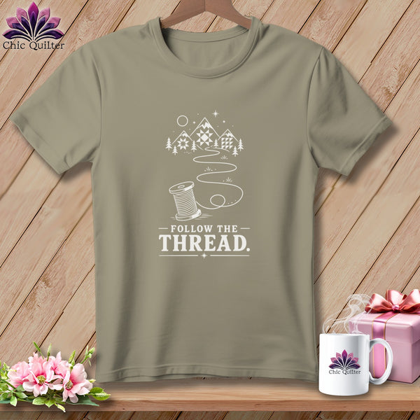 Olive t-shirt with "Follow the Thread" text and a spool of thread illustration.