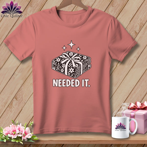 Pink t-shirt with a graphic of stacked fabric rolls tied with a bow.