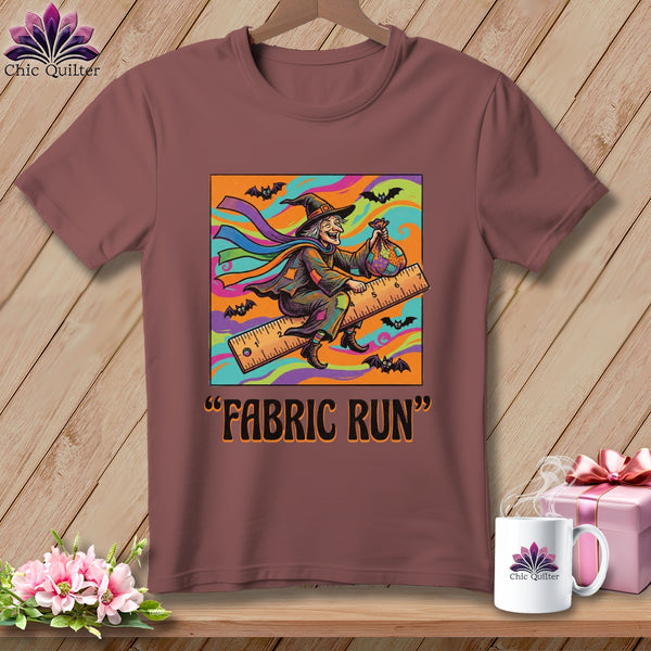 T-shirt with a graphic of a witch flying on a ruler with bats and the text "Fabric Run".