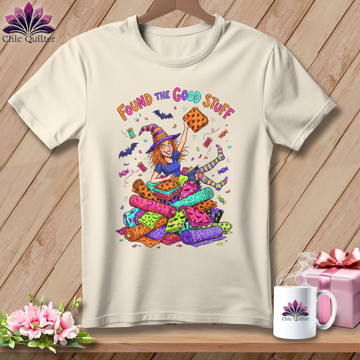 T-shirt with witch and "Found the Good Stuff" text surrounded by fabric rolls.