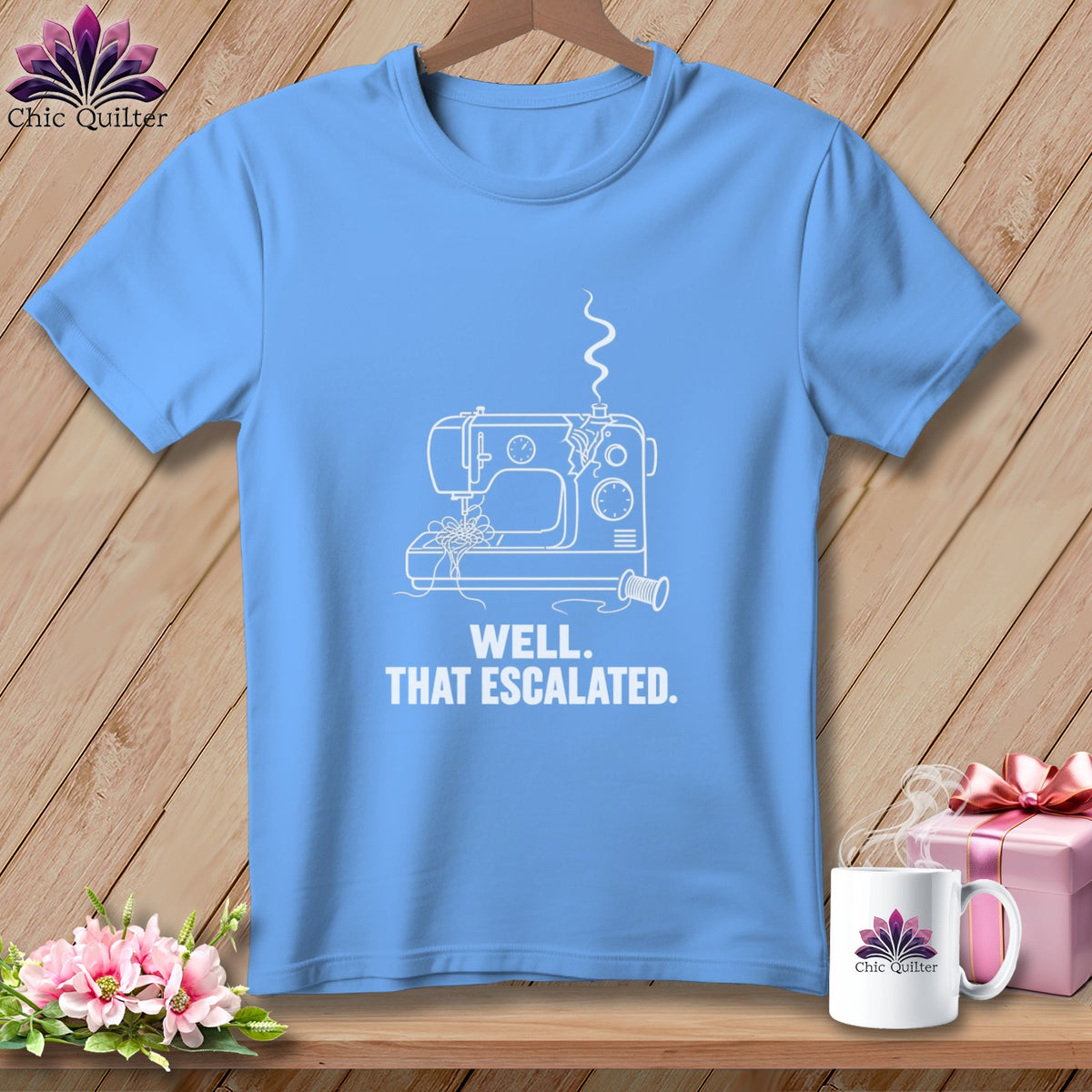 Light blue t-shirt with white line drawing of a sewing machine and text.