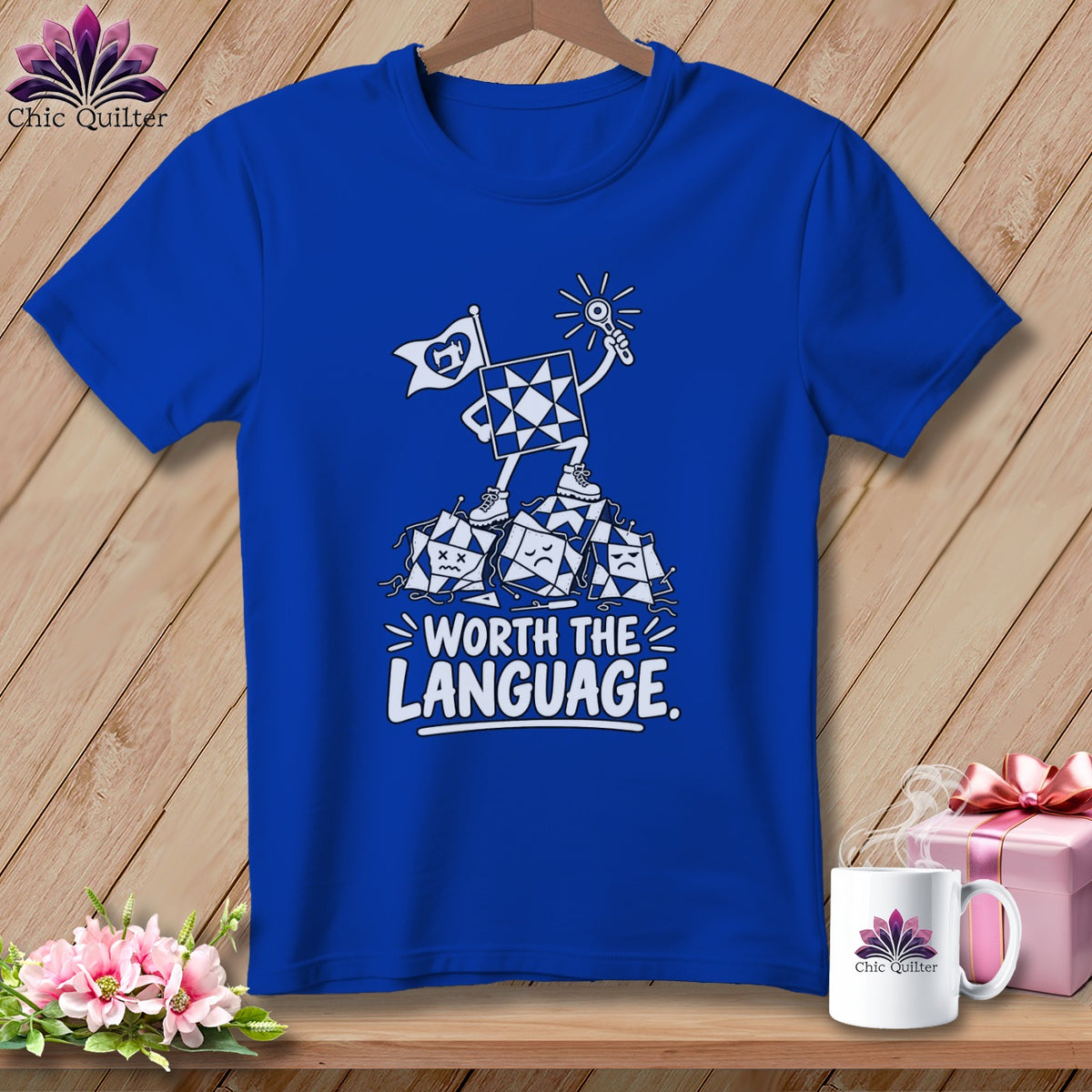 Blue t-shirt with cartoon quilt squares and the text "WORTH THE LANGUAGE."