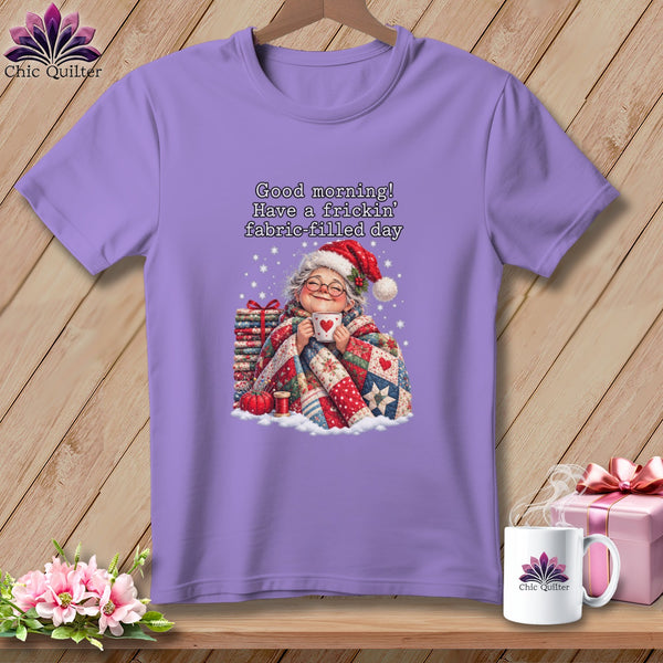A purple short-sleeved t-shirt featuring a smiling older woman holding a mug beneath text reading Good morning Have a frickin fabric-filled day.