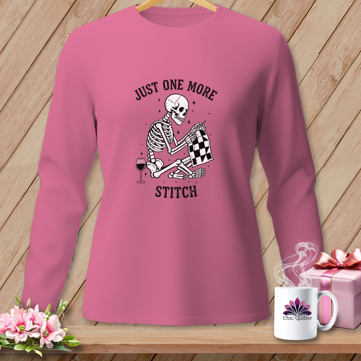 Skeleton sewing with text "Just one more stitch" on pink long sleeve shirt.