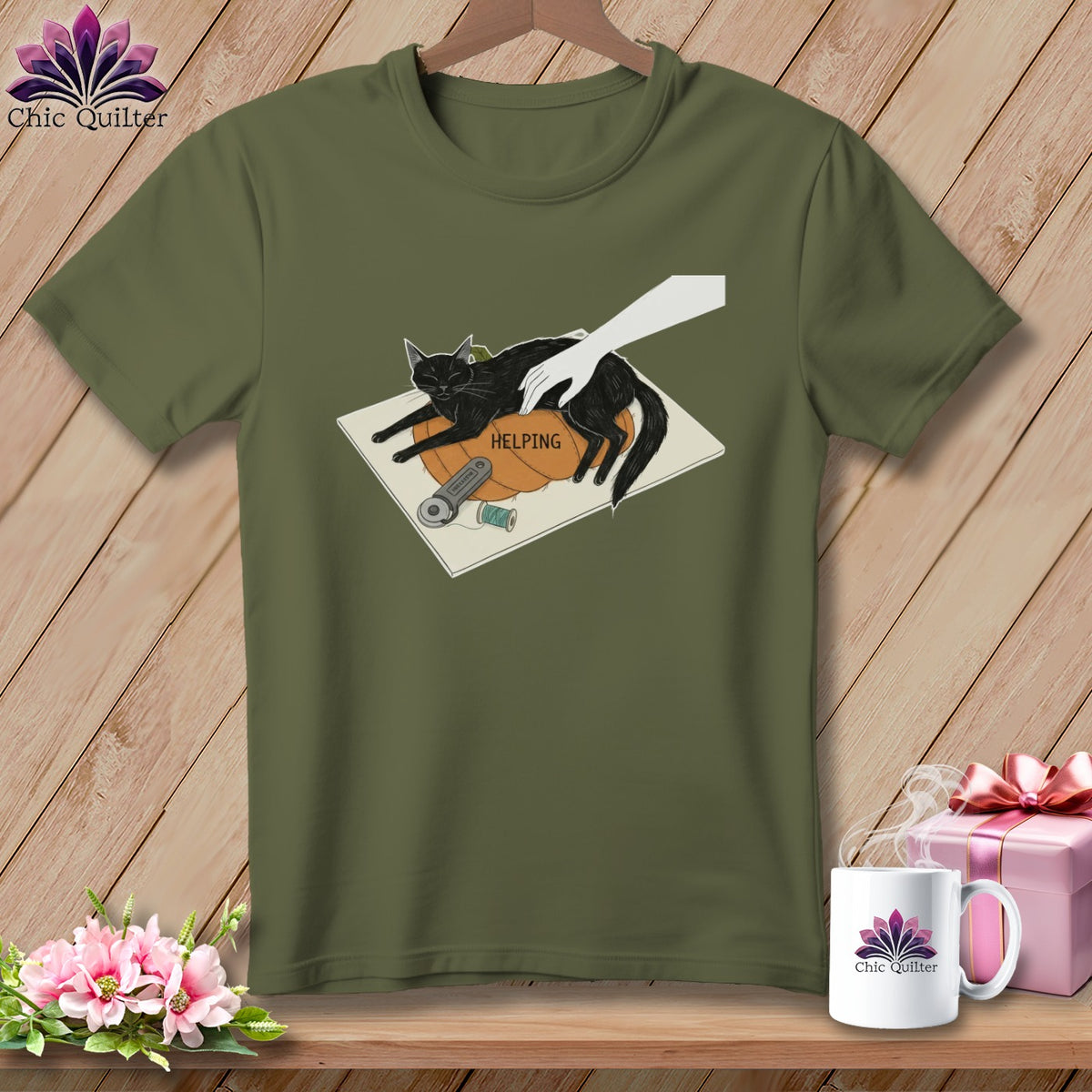 Black cat on a pumpkin with the word "HELPING", sewing supplies, and a hand.