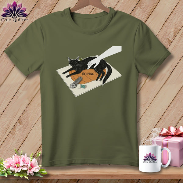Black cat on a pumpkin with the word "HELPING", sewing supplies, and a hand.