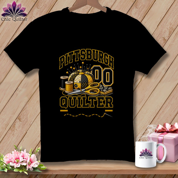 Black t-shirt featuring a yellow and black Pittsburgh Quilter graphic with a pincushion, scissors, and spools of thread.