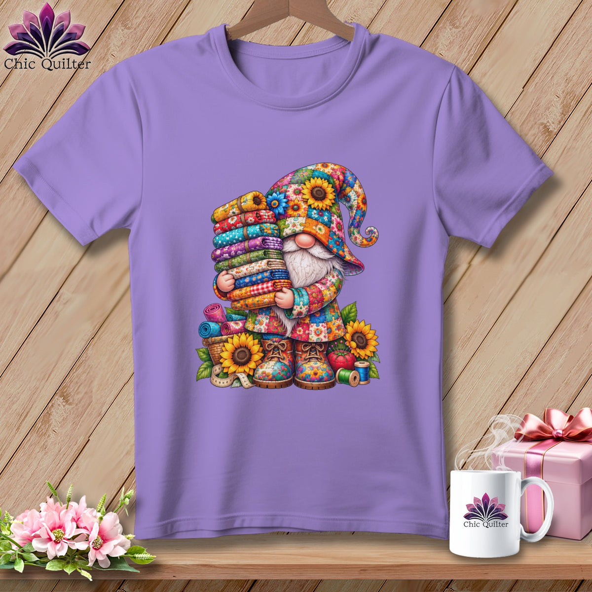 A purple t-shirt displays a graphic of a colorful gnome holding a tall stack of folded fabrics.